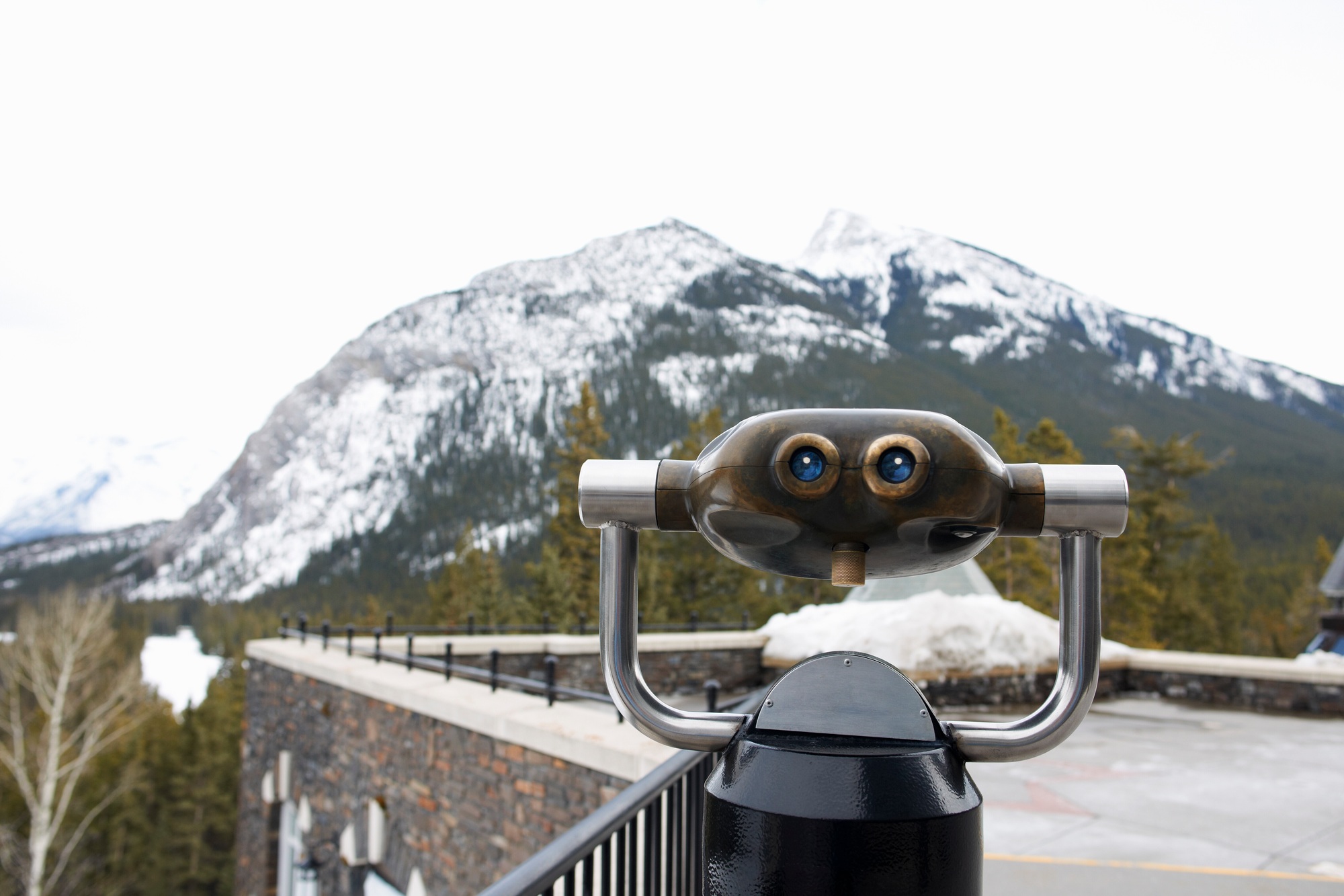 Coin operated binoculars by snow covered mountain, Banff, Canada